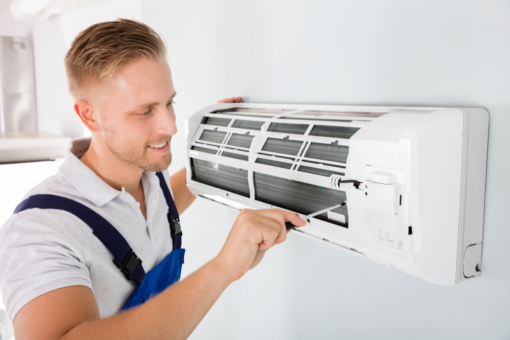 HVAC technician performing ductless air conditioning maintenance in Firestone