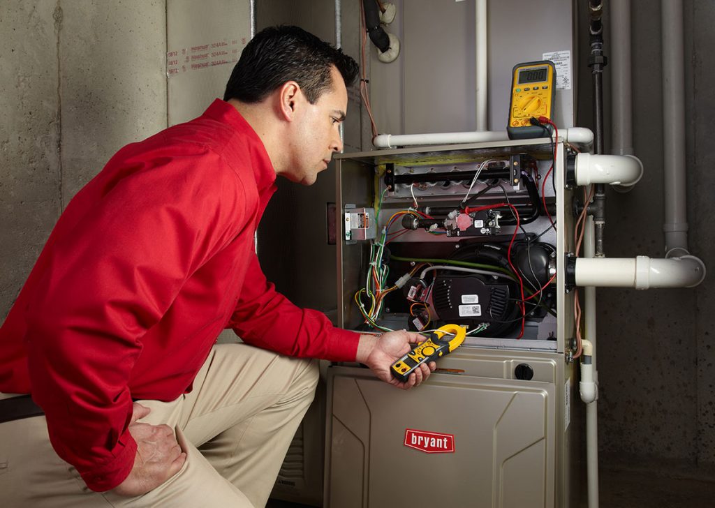 HVAC technician repairing an indoor furnace in Firestone