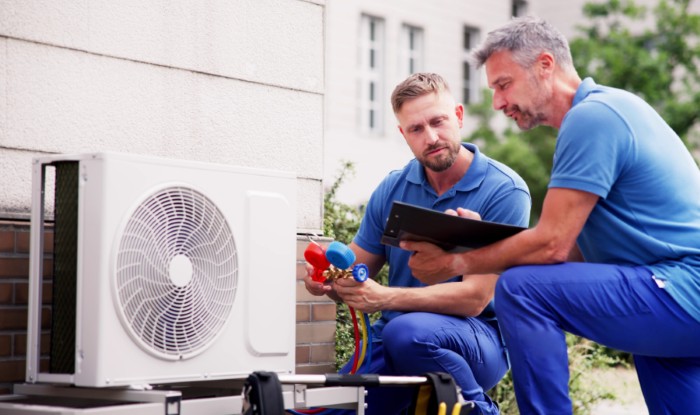 HVAC technicians installing an outdoor air conditioning unit in Firestone
