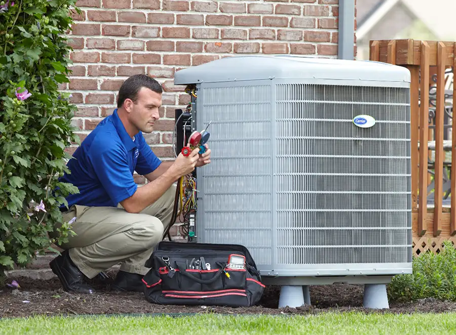 HVAC technician inspecting an outdoor air conditioning unit in Firestone