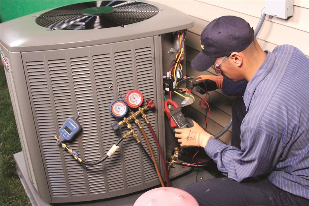 HVAC technician testing an outdoor air conditioning unit in Firestone