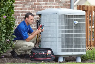 HVAC technician inspecting an outdoor air conditioning unit in Firestone, CO